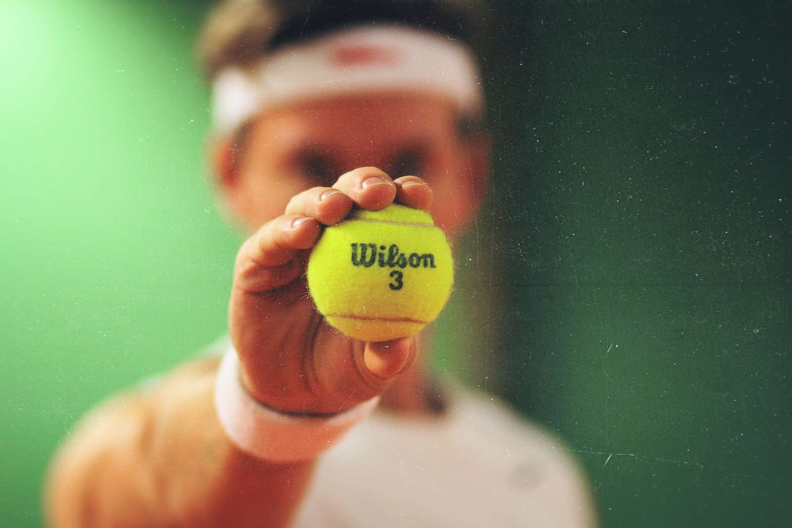 person zeigt grünen tennis ball